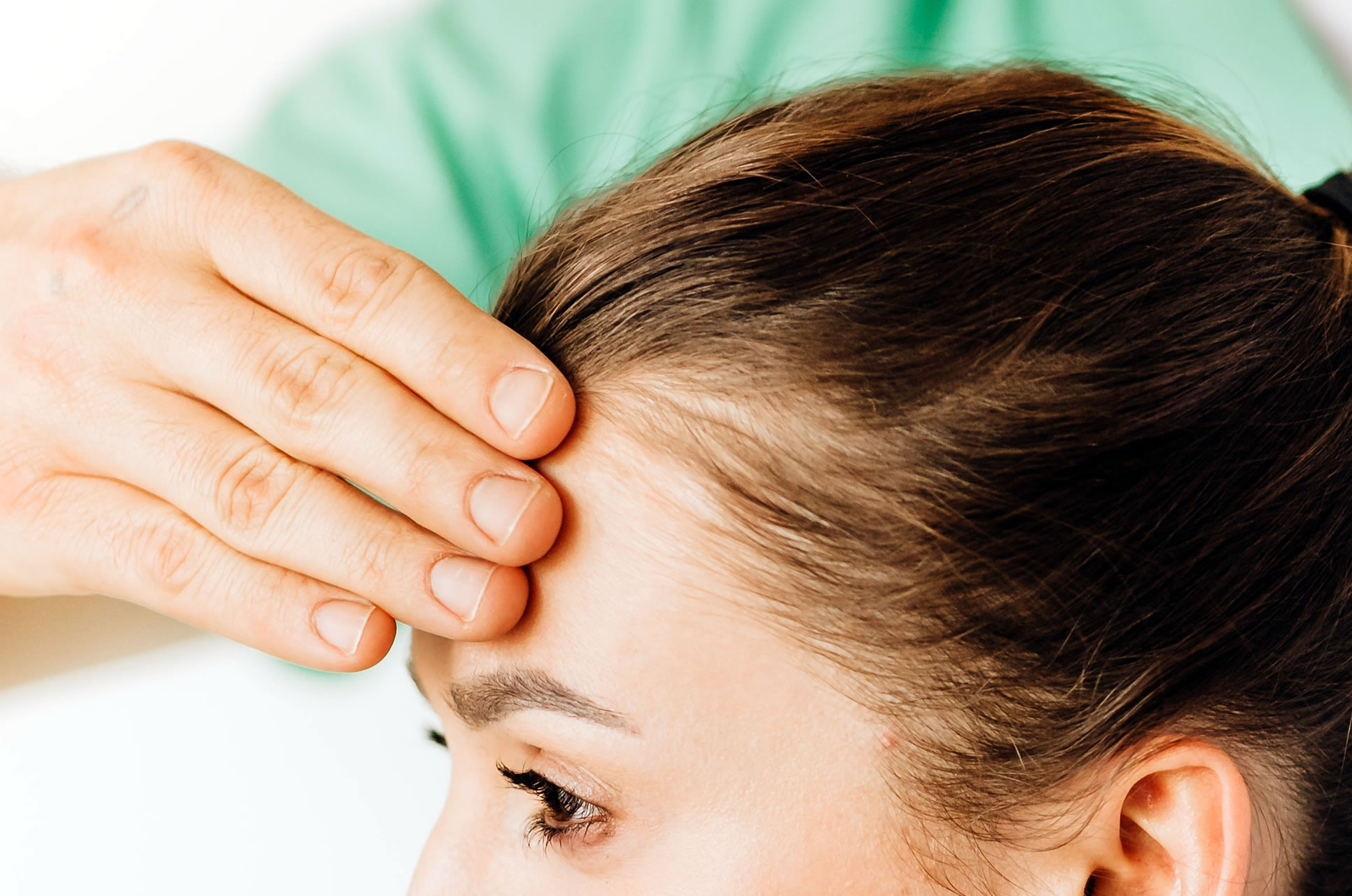 therapist examining patient's forehead