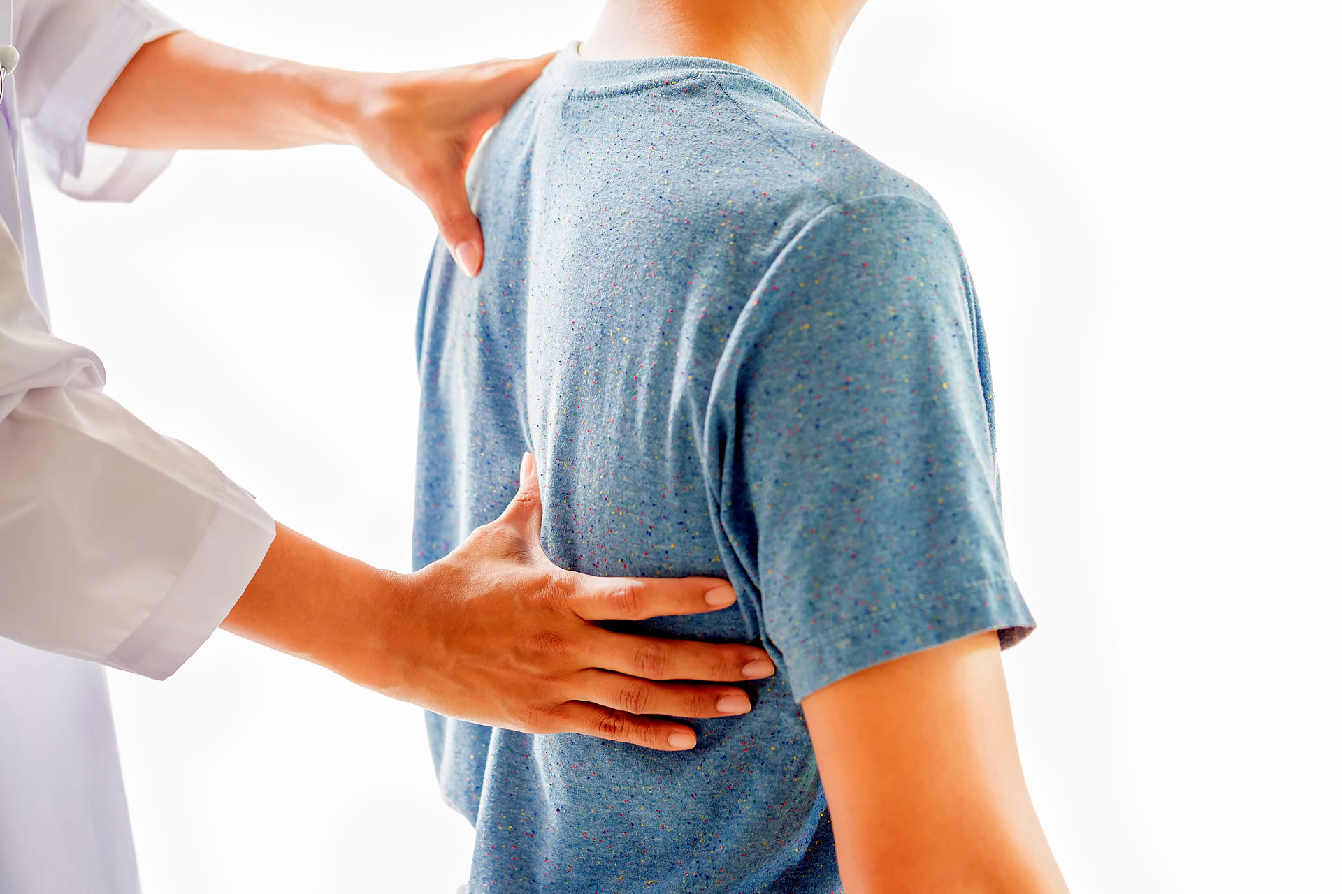 therapist examining patient's back